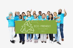 A group of people posing with an eco-friendly sign for their franchise business.