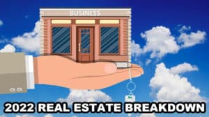 A hand holding a building with the words 2022 real estate breakdown in the commercial real estate market analysis.