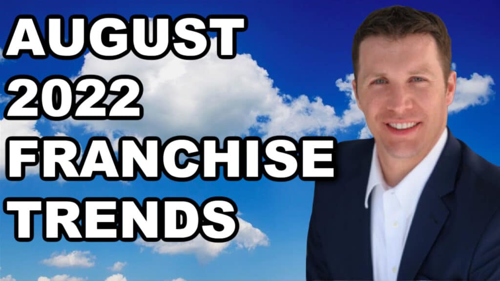 A man in a suit discussing franchise trends for August 2022, alongside franchise brokers.