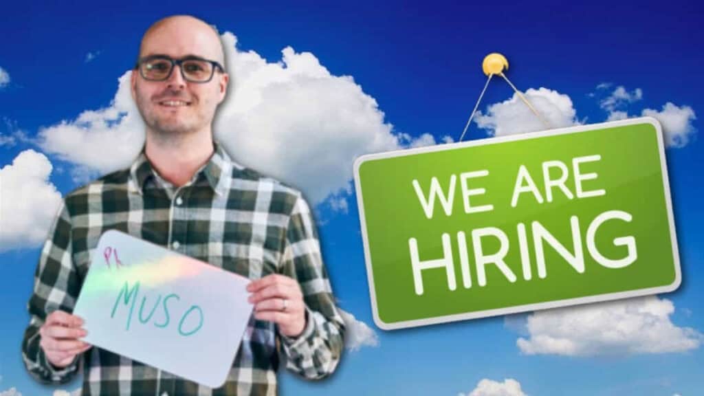 A man holding up a sign that says we are hiring against a blue sky background