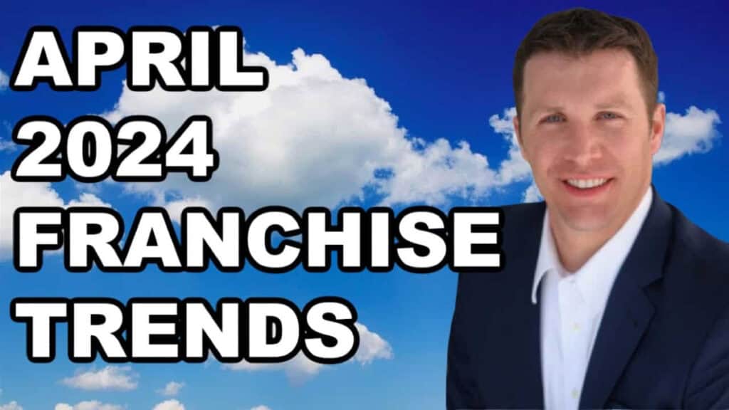 Smiling man in suit with text "franchise trends" against a blue sky background.